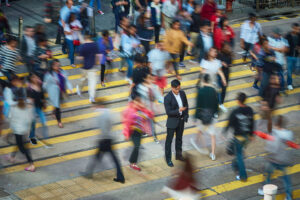 businessman with phone in busy crosswalk