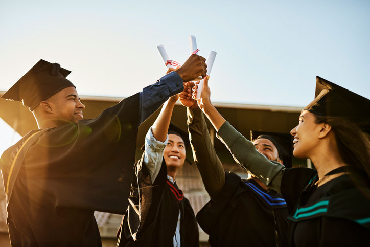 group of graduates celebrating with diplomas