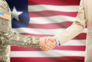 uniformed soldier shaking hands with a civilian