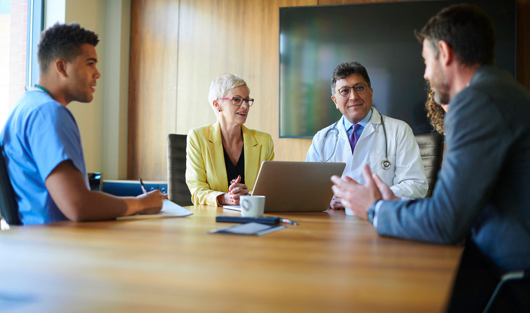 healthcare manager in meeting with staff