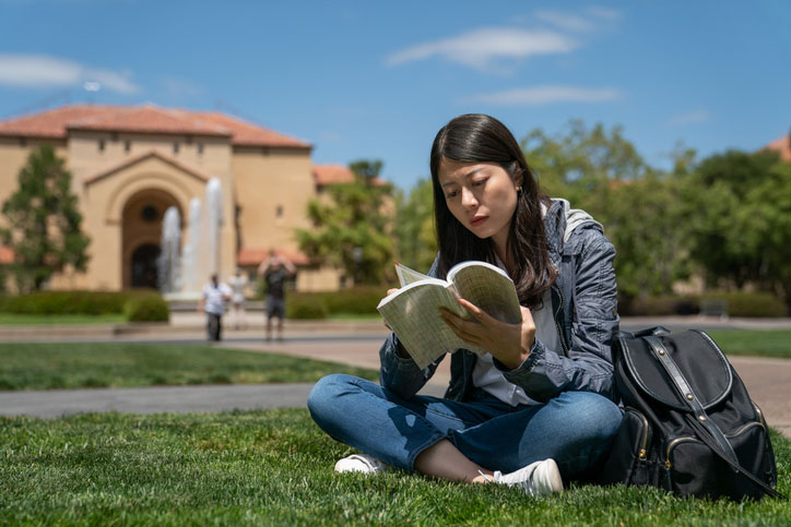 young woman reading in the grass