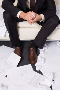 businessman surround by crumpled paper