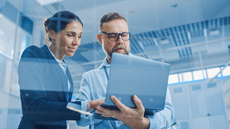 stylish business people looking at laptop in lab