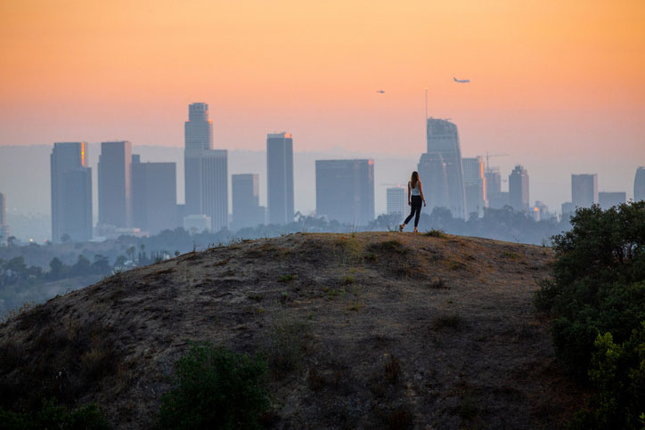 woman on hill with city in the background