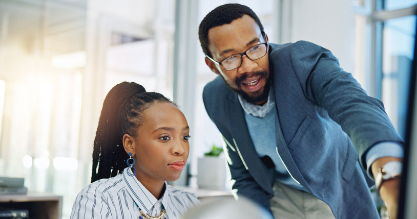 man and woman working on computer together